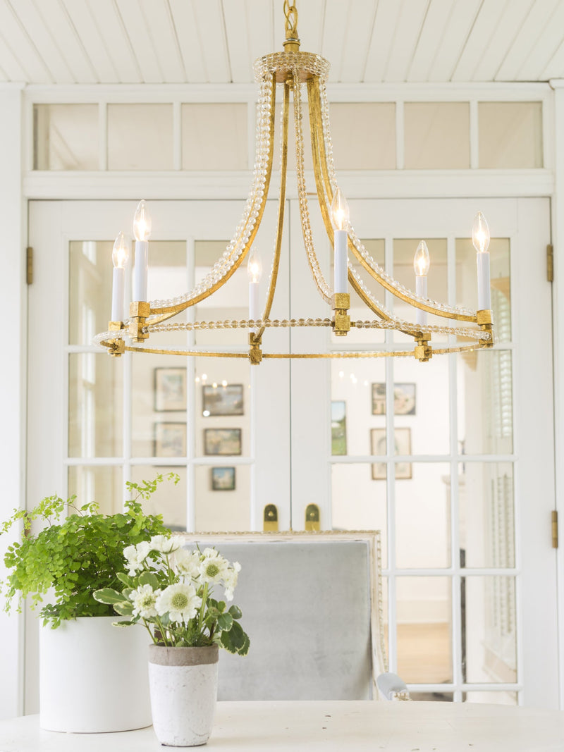 Decorative Crafts handmade Italian gold chandelier with crystal bead accents illuminating a bright dining space.