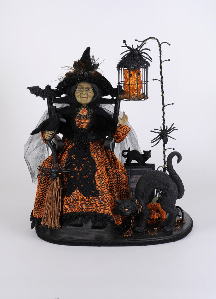 Halloween-themed decorative figure with a witch, cats, and a broom on a white background