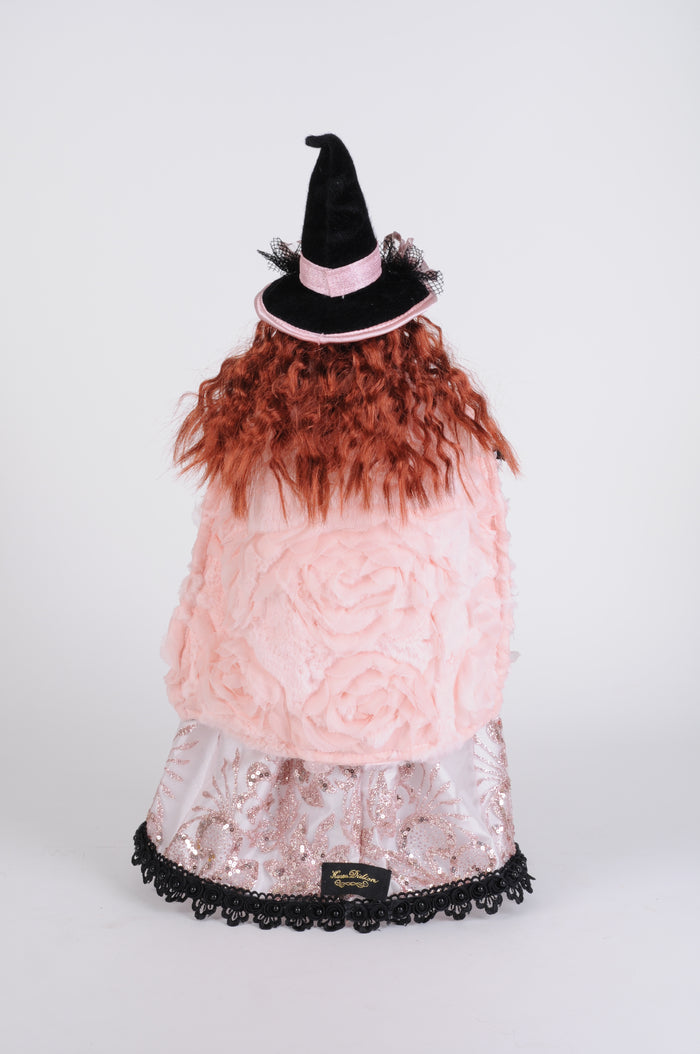 Pink dress with black lace trim and brown feathered skirt on a white background
