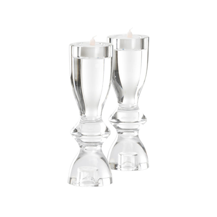 Two clear glass candle holders on a white background