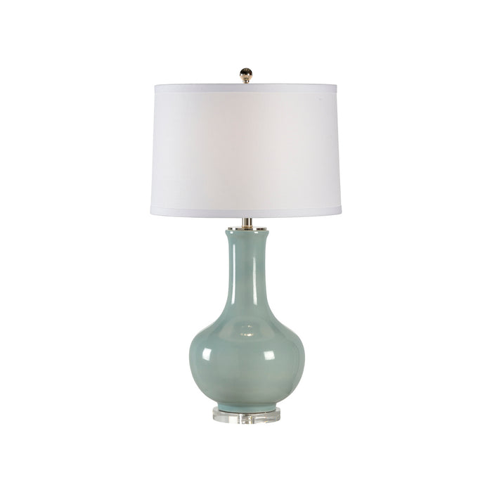 Table lamp with a light blue ceramic base and white shade on a white background
