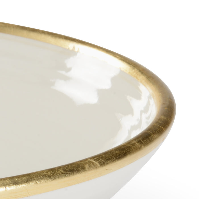 White dish with a gold rim on a white background