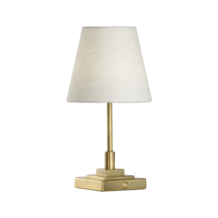 Table lamp with brass base and white shade on a white background