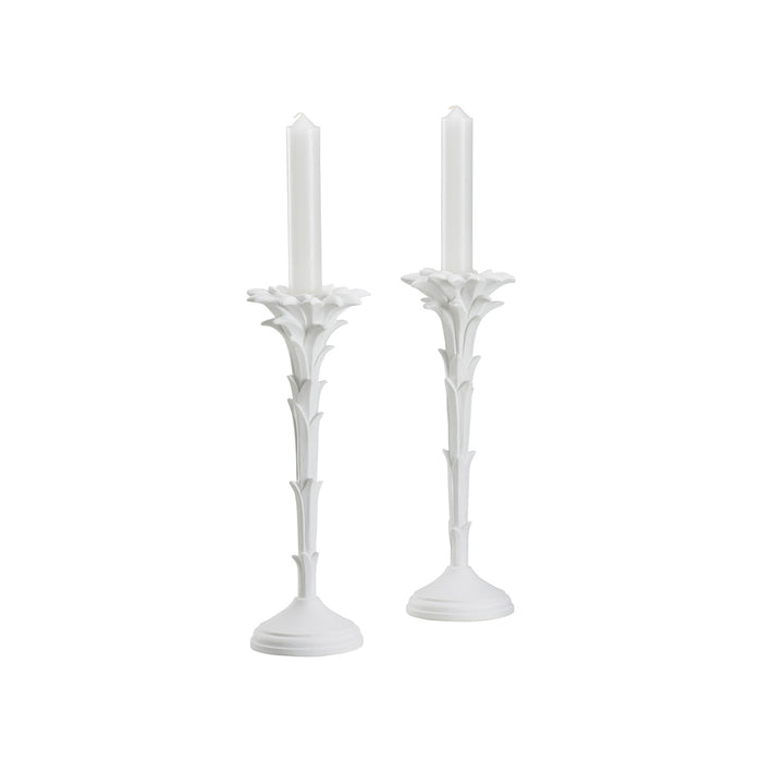 Two white candle holders with candles on a white background
