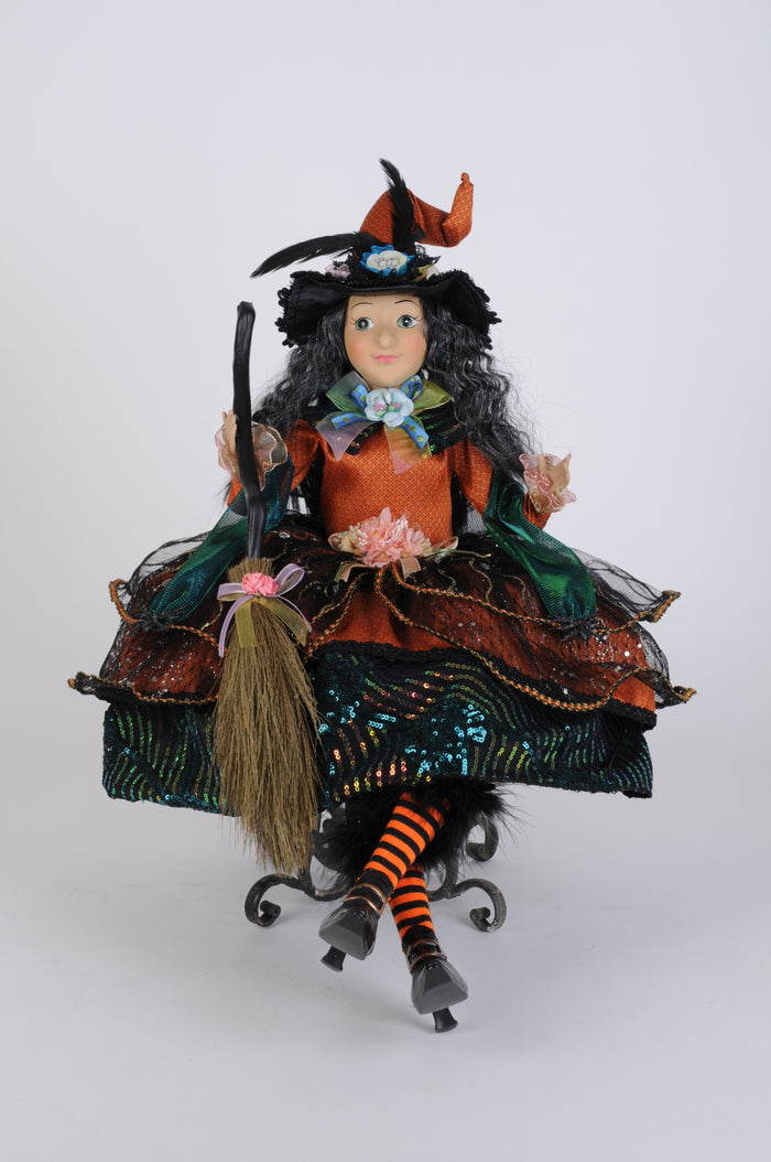 Decorative witch figurine with a broom on a white background