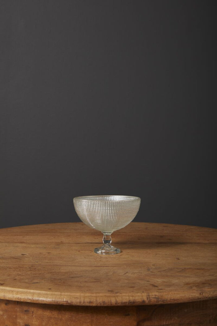 Clear glass bowl on a wooden table with a dark background