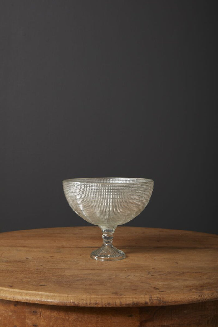 Decorative glass bowl on a wooden table with a dark background