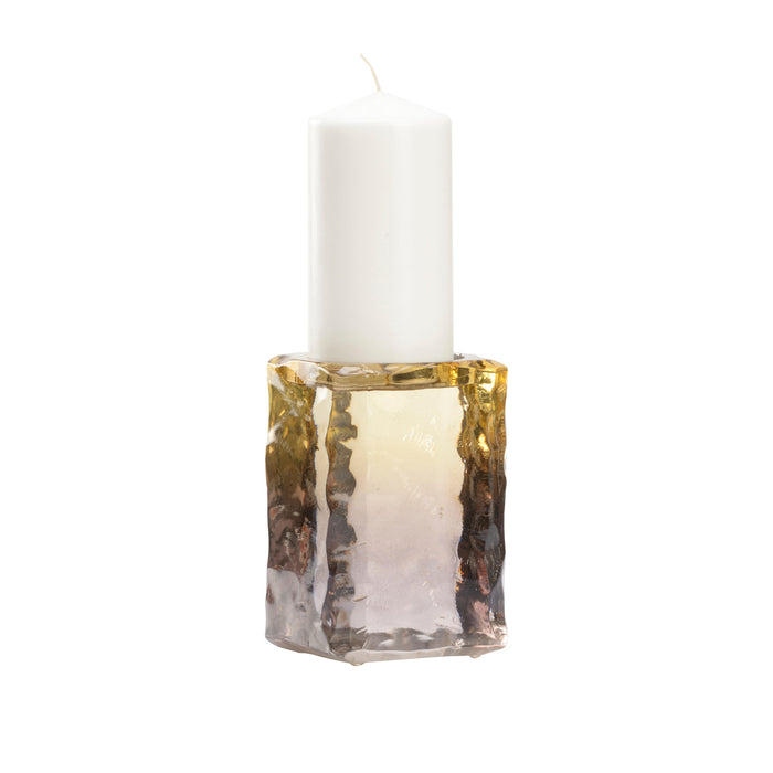 White candle in a decorative glass holder on a white background