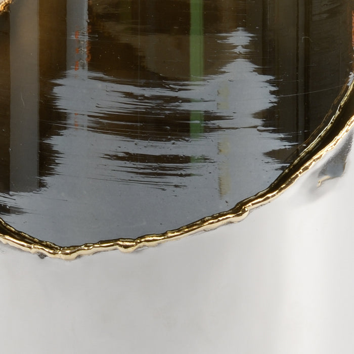 Close-up of a black plate with a gold rim on a white surface