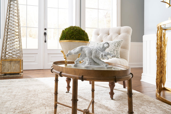 Round wooden coffee table with decorative items in a living room setting.