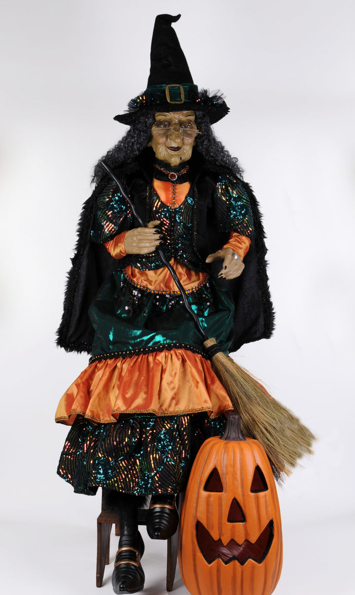 Halloween witch figurine with broom and pumpkin on a white background