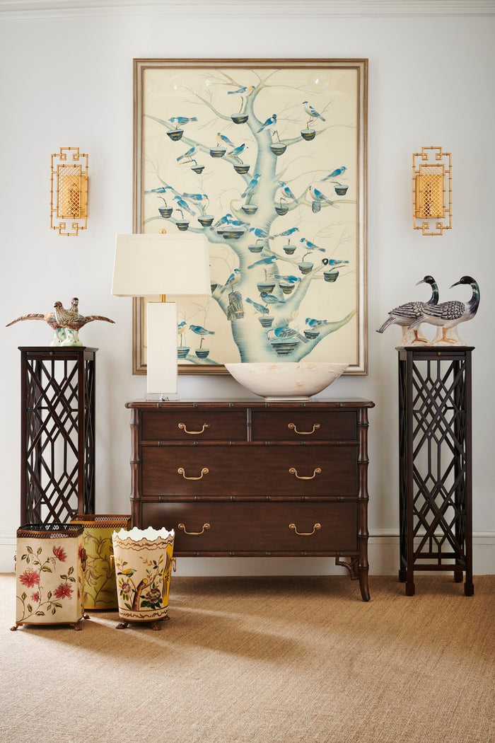 Decorative room setting with a dresser, lamps, and wall art.