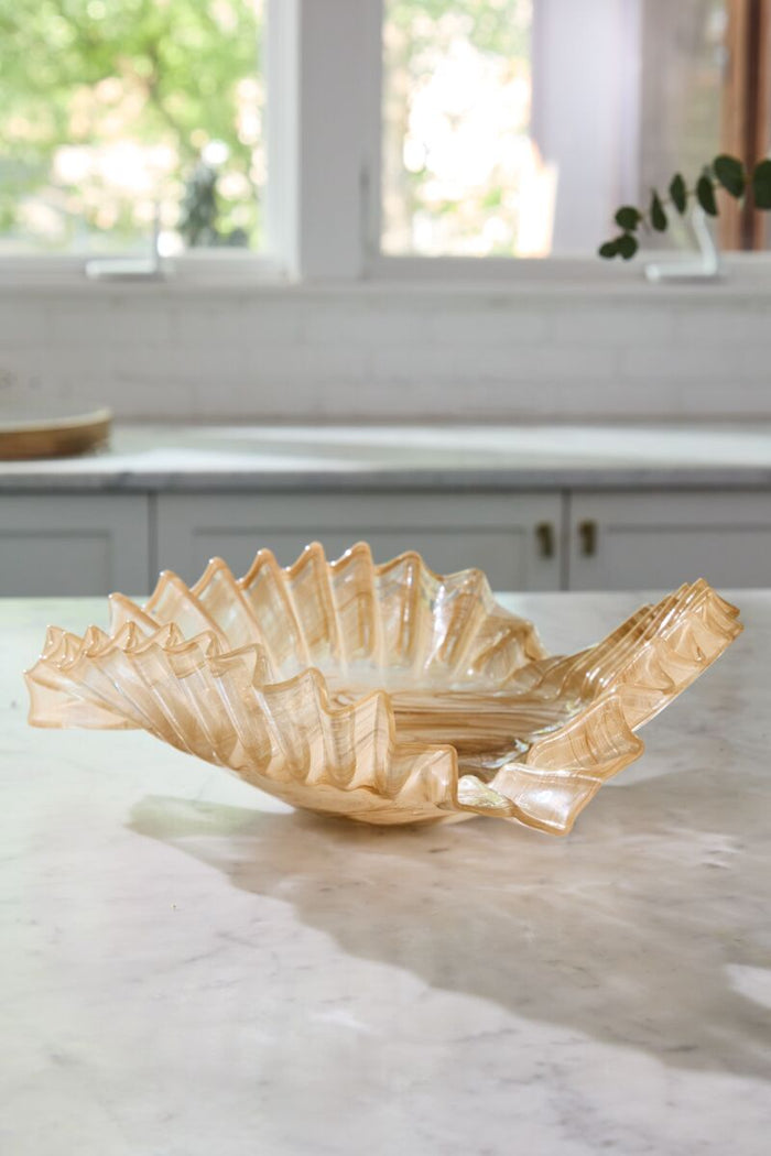 Decorative glass bowl on a marble surface with a kitchen background