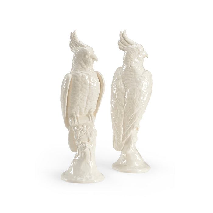 Two white ceramic parrot figurines on a white background