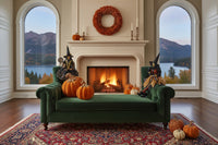 Halloween-themed decorations with witches, pumpkins, and a wreath on a green couch.