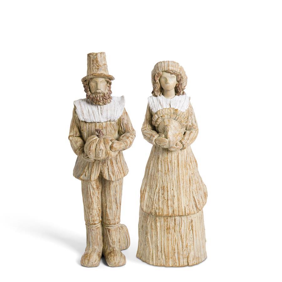 Two decorative figures of a man and woman in historical attire on a white background
