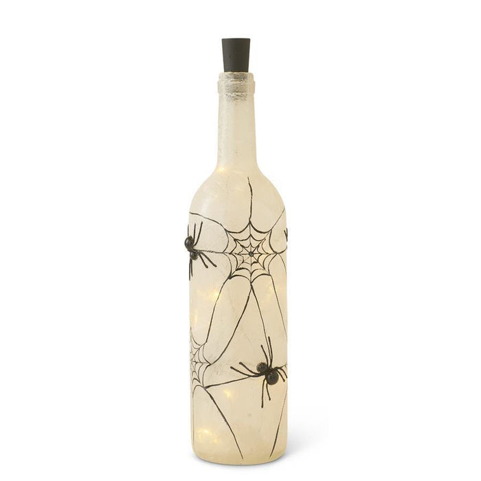 Decorative wine bottle with spider web and spider designs on a white background