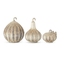 Three decorative pumpkins with textured surfaces on a white background