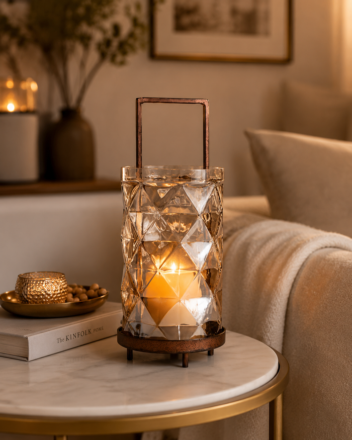 Decorative lantern with a candle on a marble table in a cozy living room setting.
