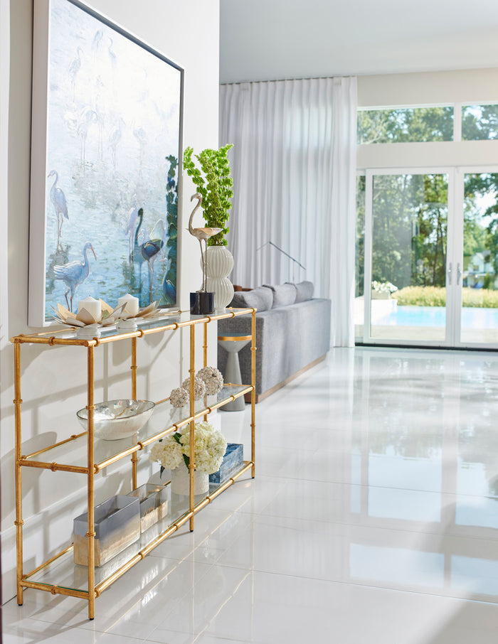 Gold console table in a modern living room with white decor