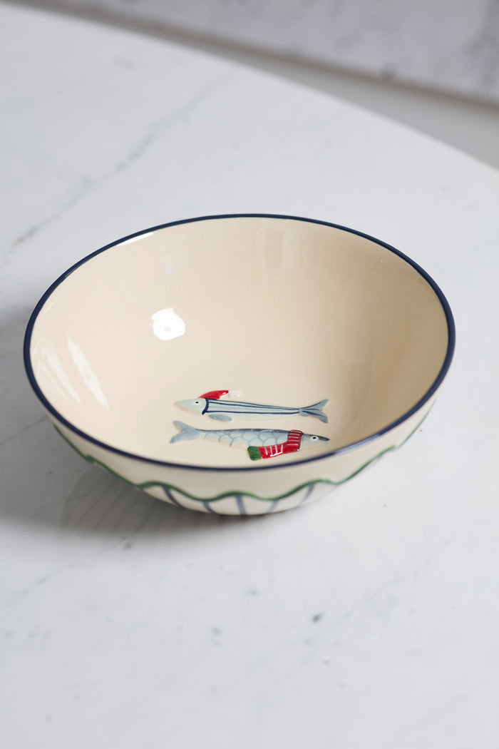 Ceramic bowl with fish design on a white surface