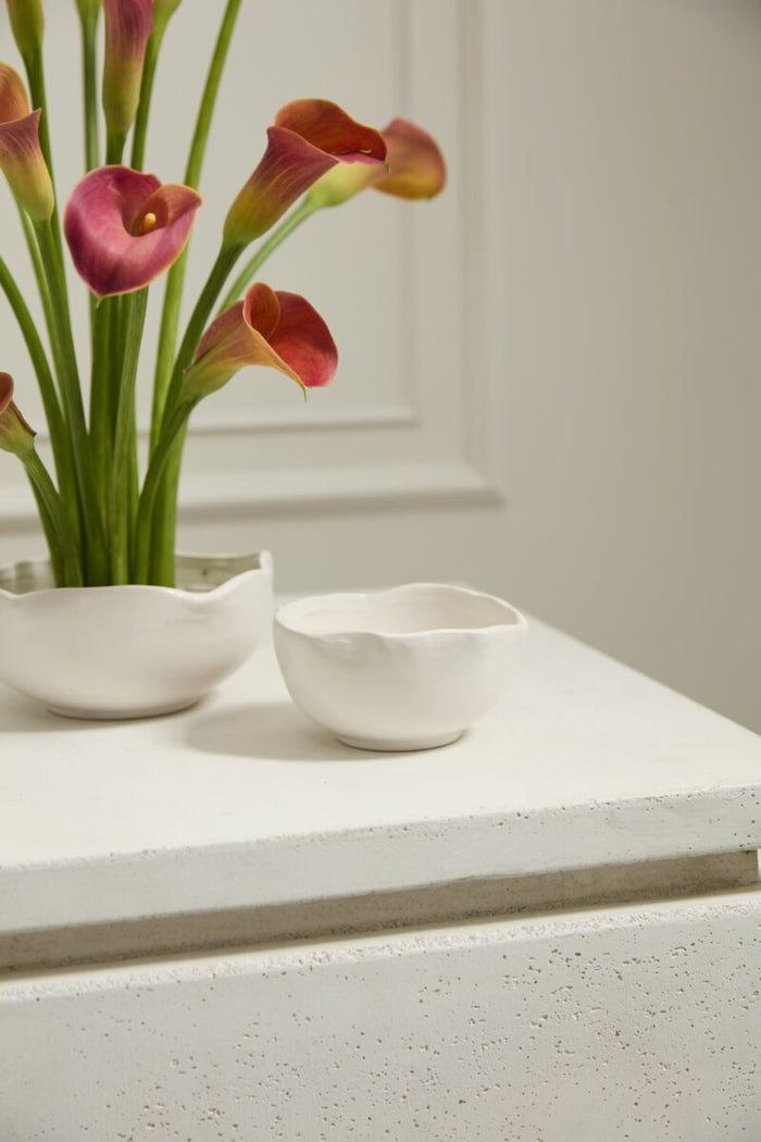 White ceramic bowls with pink and green flowers on a white surface