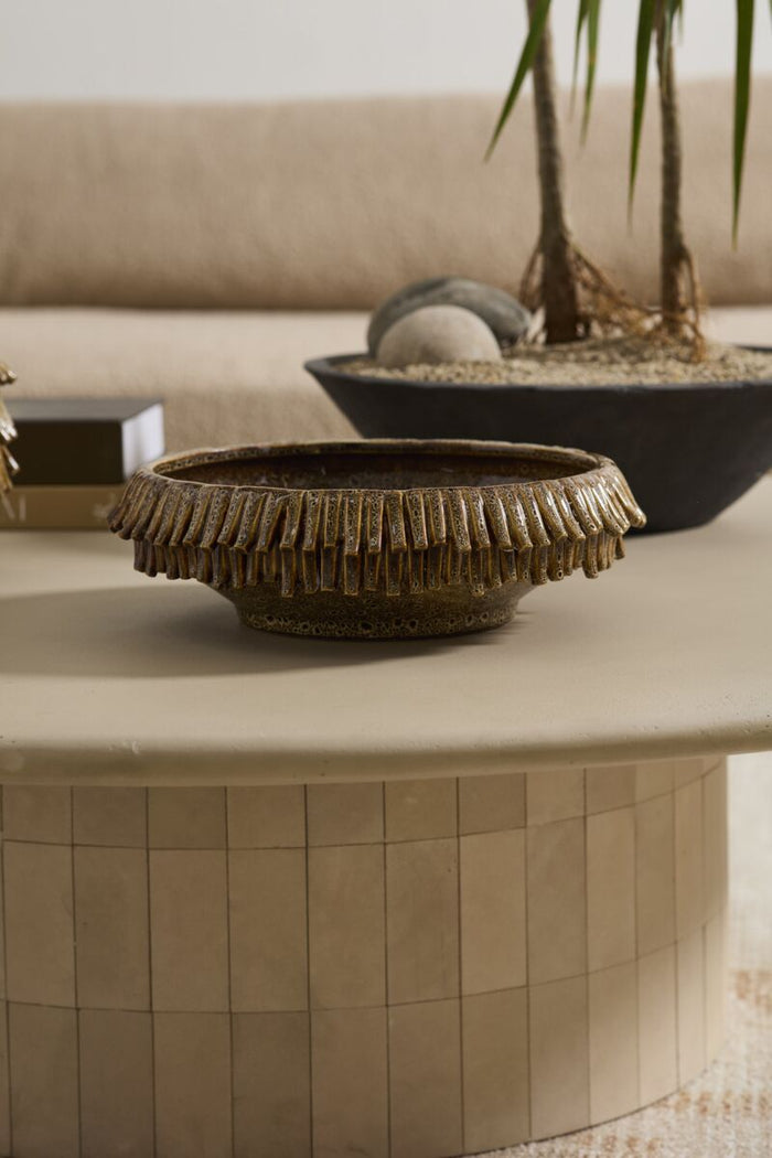 Decorative bowl on a round stone table with a blurred background
