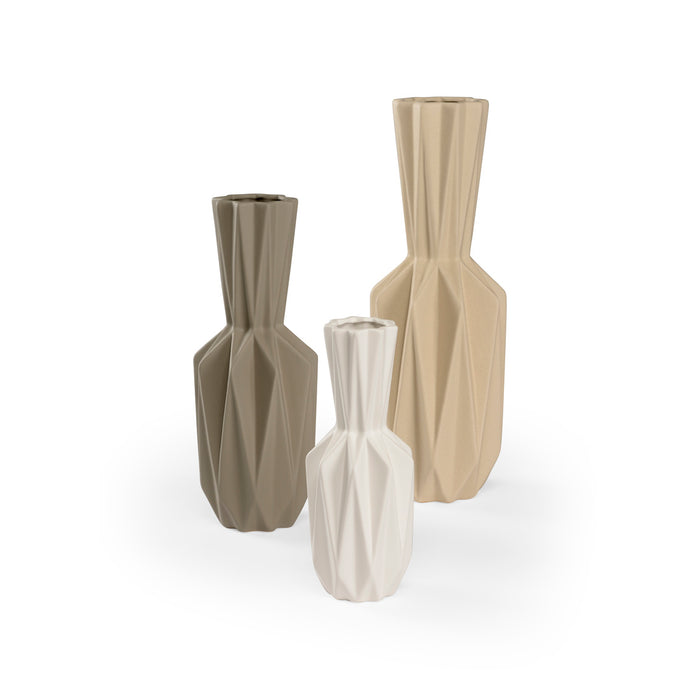 Three geometrically designed vases in beige, brown, and white on a white background