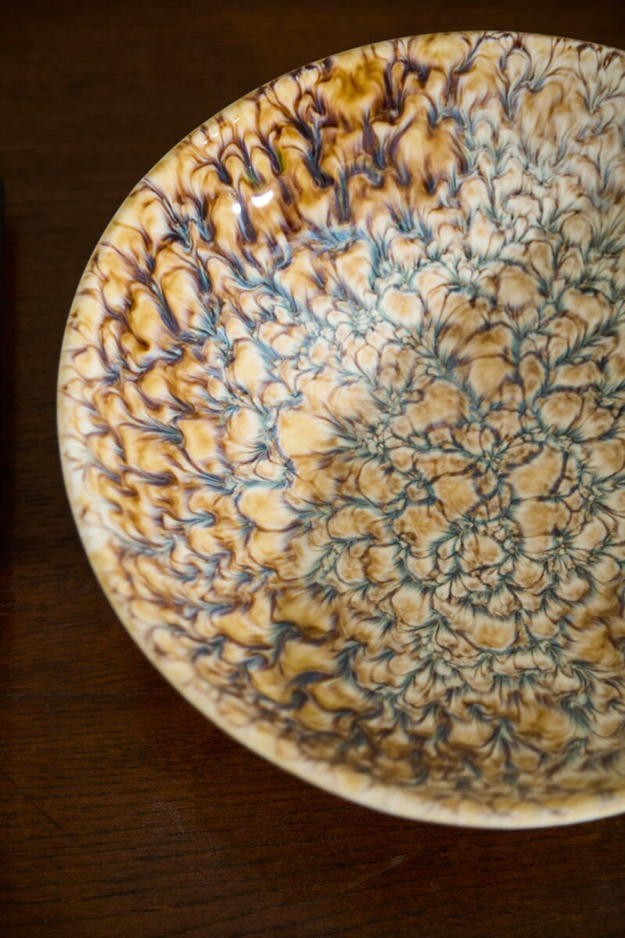Decorative ceramic bowl with intricate patterns on a wooden surface