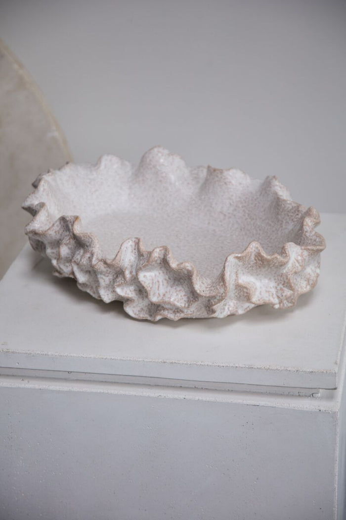 Decorative ceramic bowl with a textured surface on a white surface.