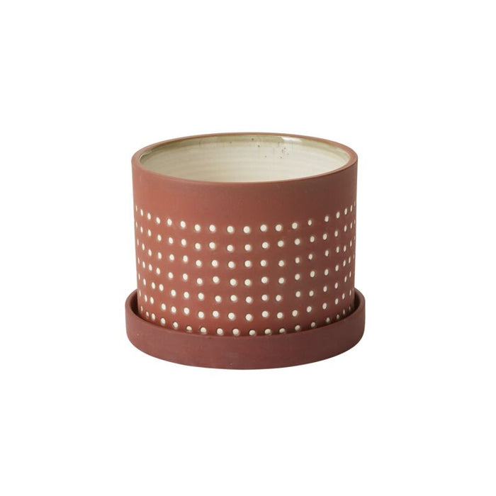Ceramic pot with perforated design on a white background