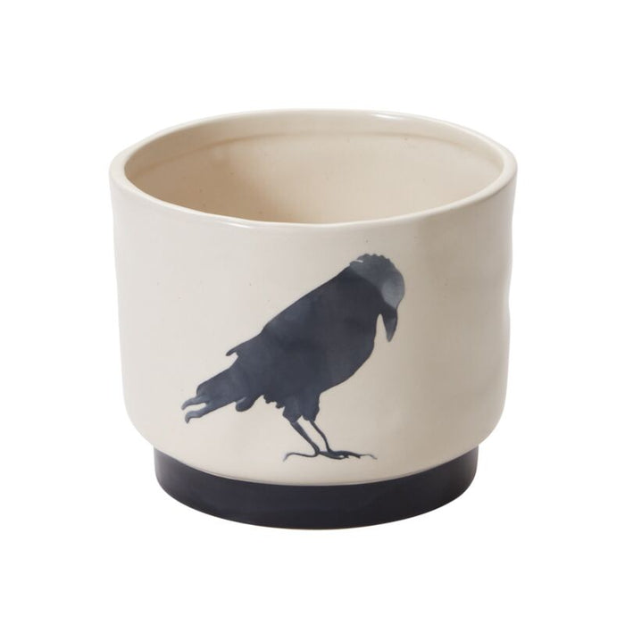 Ceramic pot with a black bird silhouette on a white background