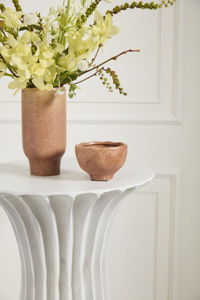 Two ceramic vases on a white surface with a neutral background