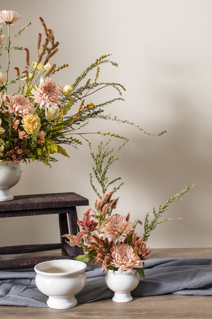 Floral arrangement on a wooden surface with a neutral background