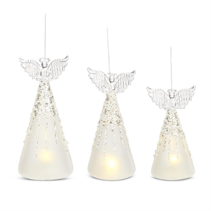 Three angel-shaped candle holders with LED lights on a white background