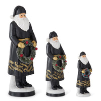 Set of 3 Resin Black Coat Santas Holding Bottle Brush Wreath