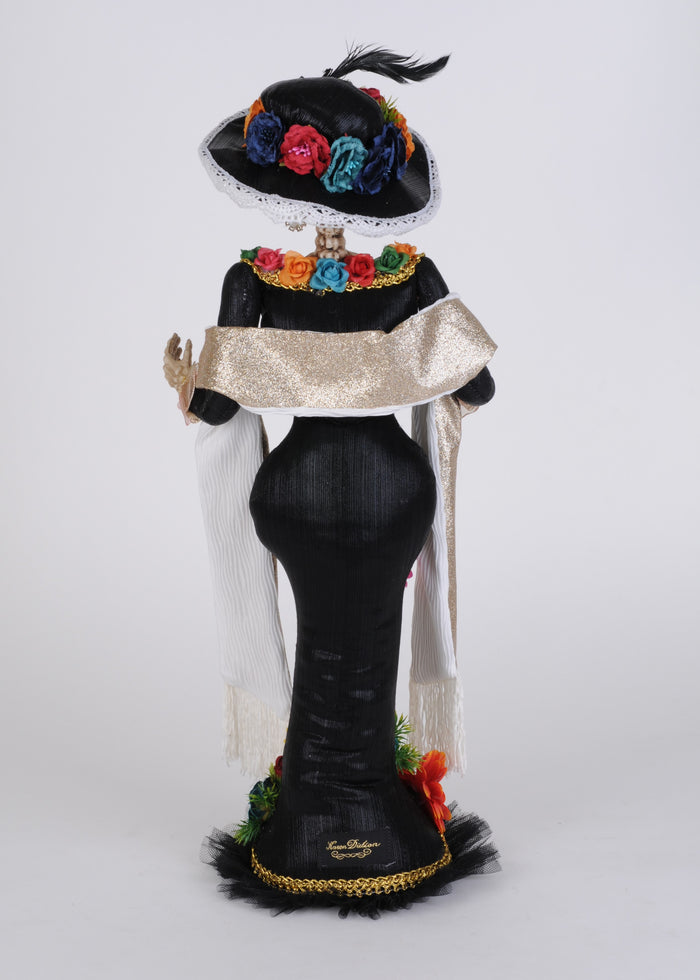 Decorative figure of a skeleton in traditional attire with colorful flowers on a white background