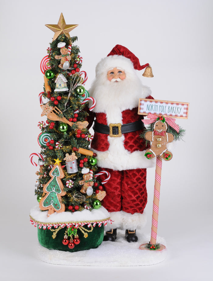 Decorative Christmas scene with a Santa figure, Christmas tree, and gingerbread man sign on a white background.