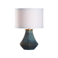 Table lamp with a geometric blue base and white shade on a white background