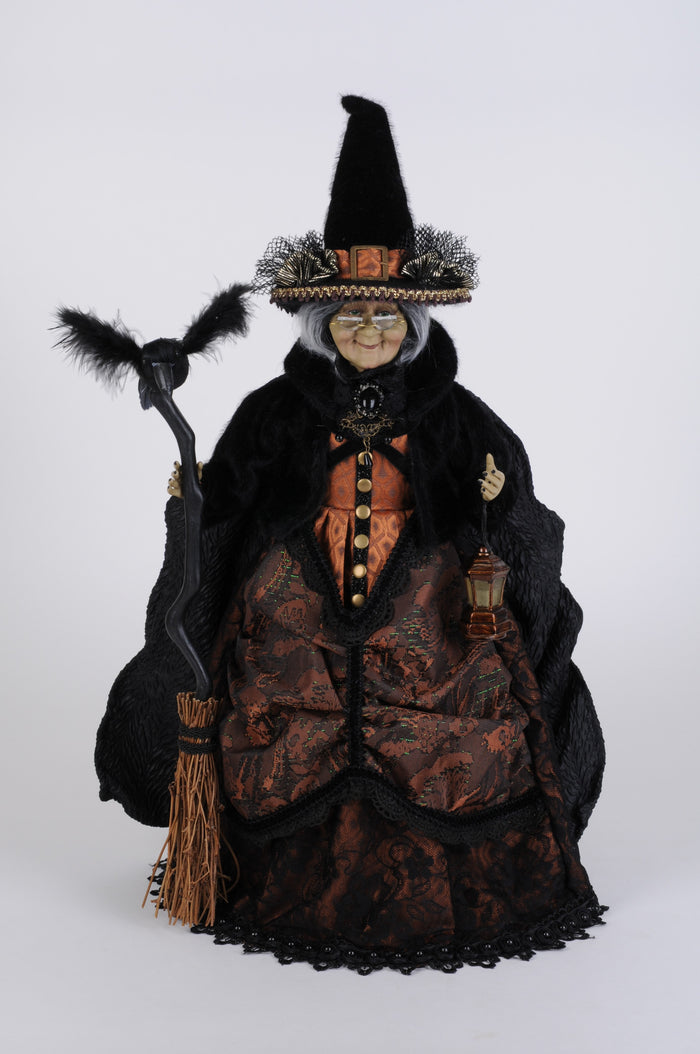 Decorative witch figurine with a broom on a white background