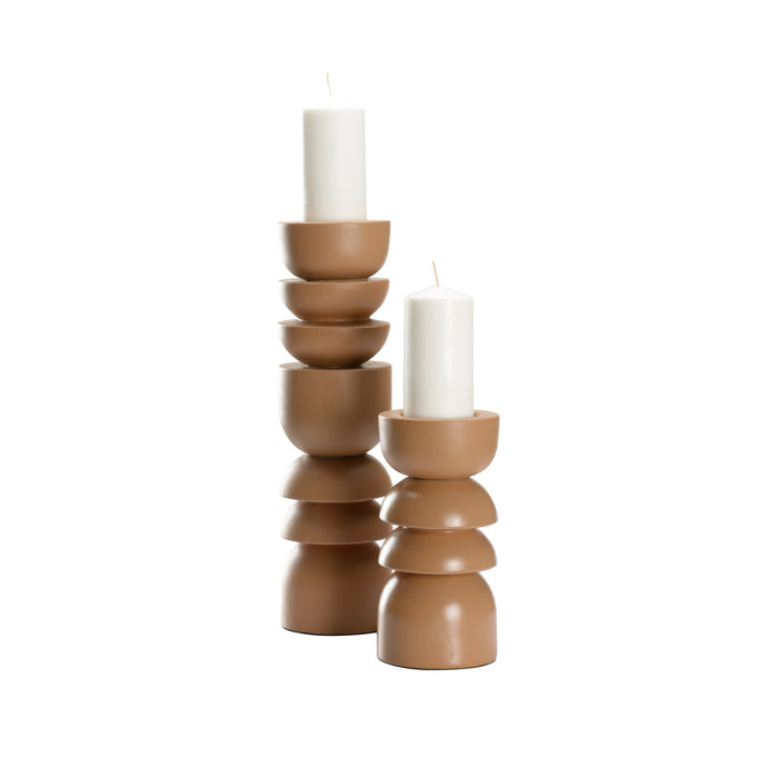 Stacked brown ceramic candle holders with white candles on a white background