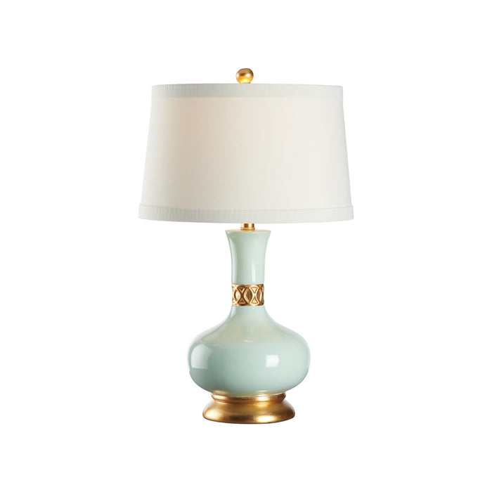 Table lamp with a light green ceramic base and gold accents on a white background