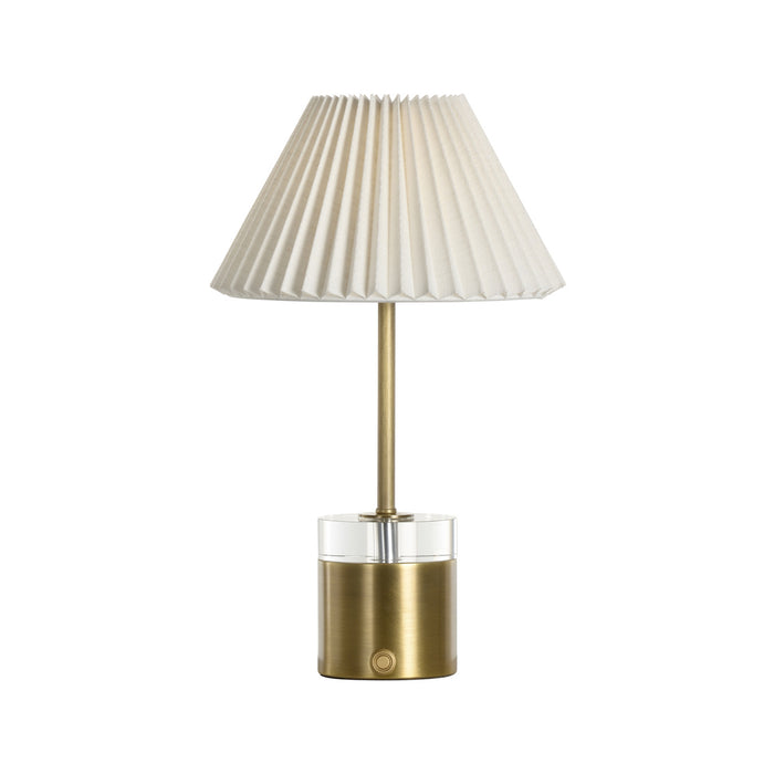 Table lamp with pleated white shade and brass base on a white background