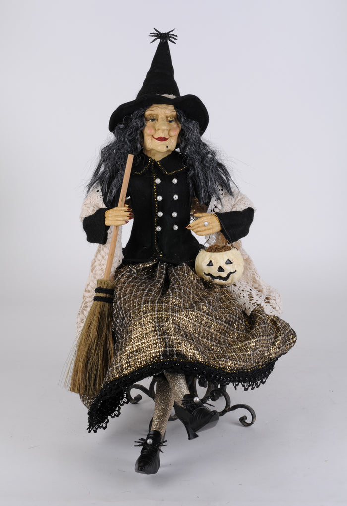 Halloween witch doll with broom and pumpkin on a white background