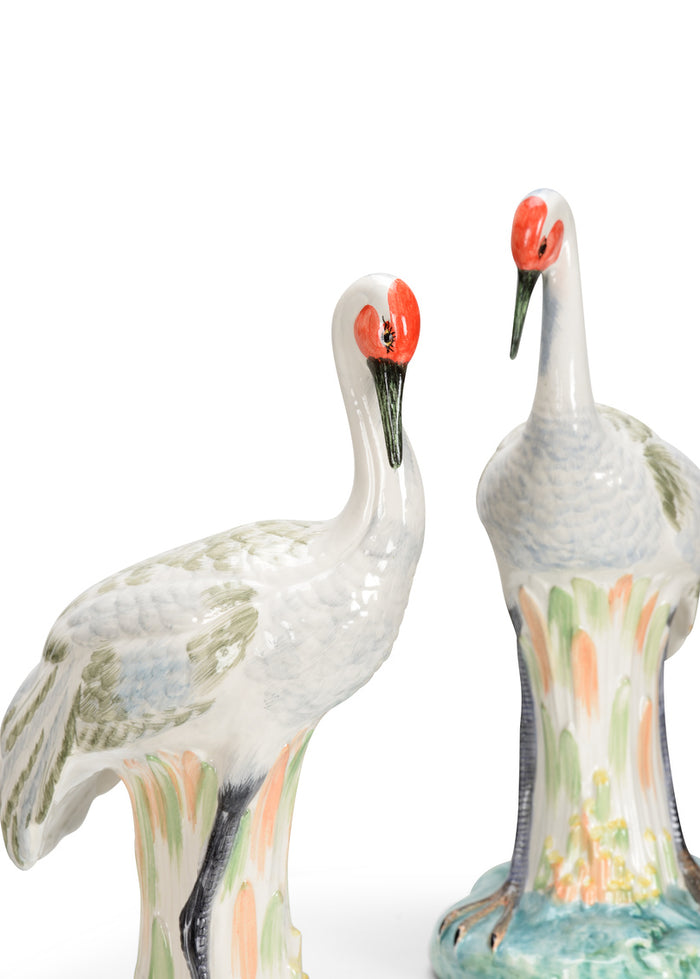Two ceramic cranes with colorful patterns on a white background