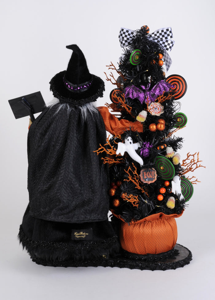 Halloween-themed tree with decorations and a witch figure on a white background