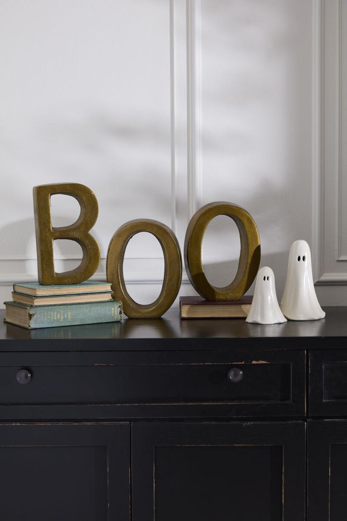 Decorative setup with 'BOO' letters on a shelf against a dark wall.