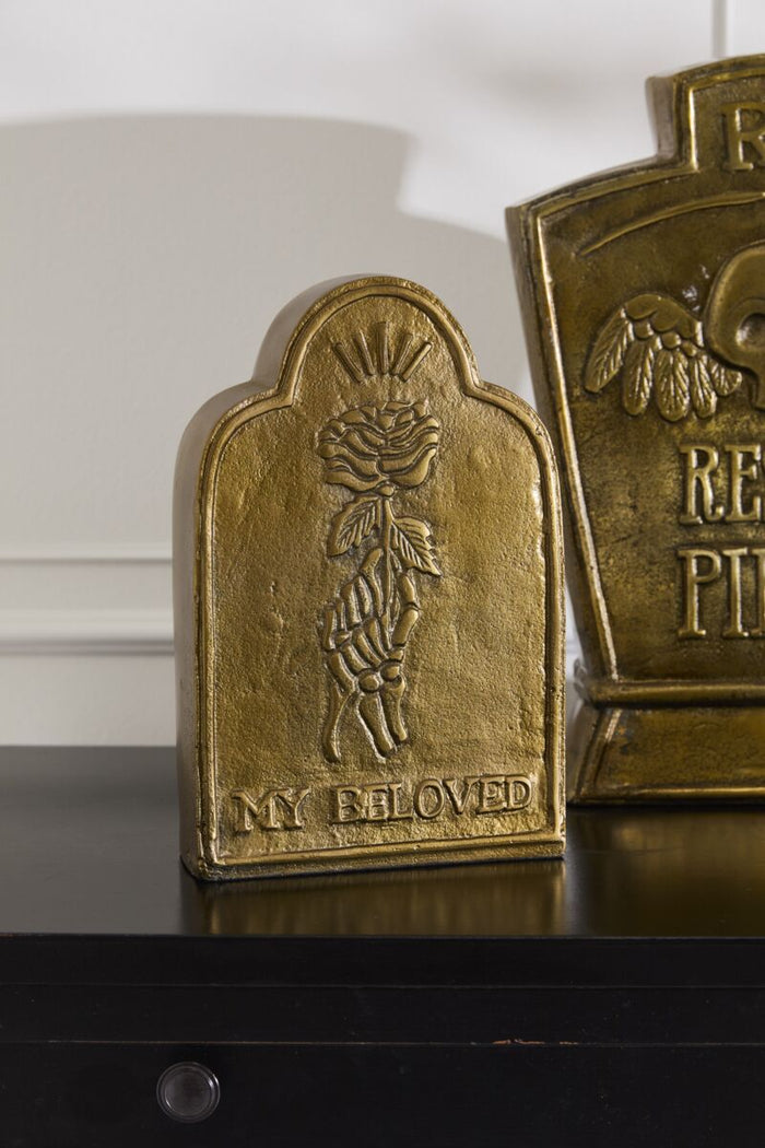 Gold decorative plaque with engraved design on a reflective surface