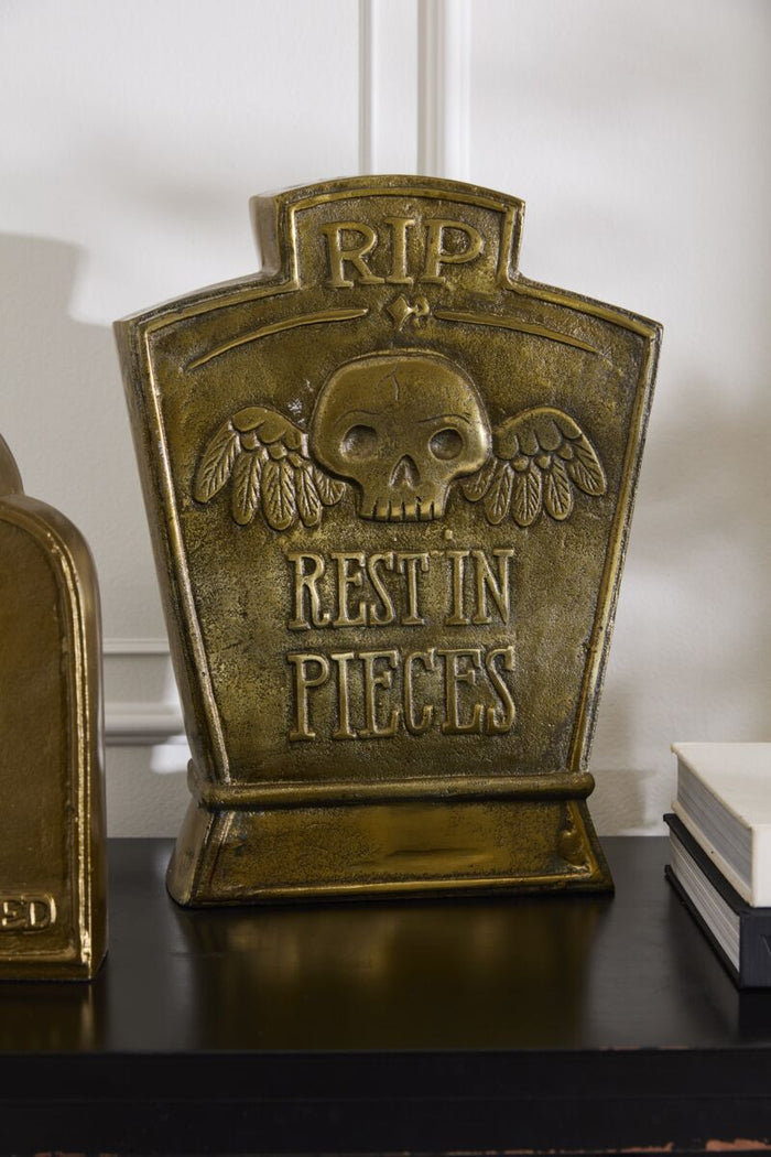 Decorative tombstone with 'RIP Rest in Pieces' text on a shelf.