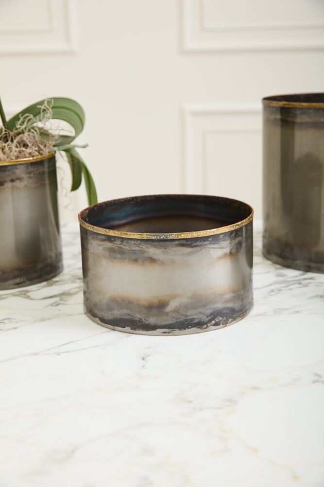 Three ceramic planters with gold rims on a marble surface.